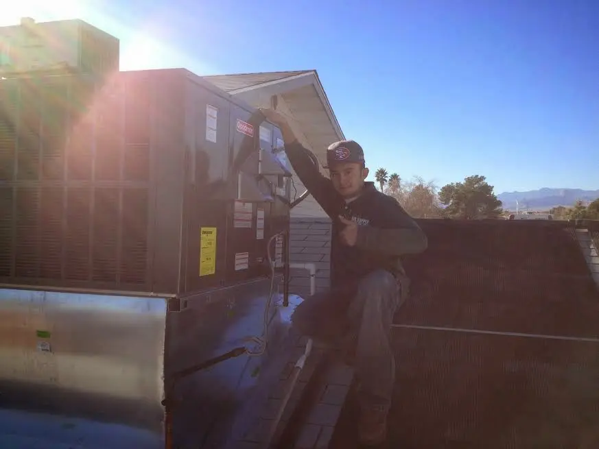 HVAC technician performing AC Tune-Up on a rooftop unit in Clear Lake
